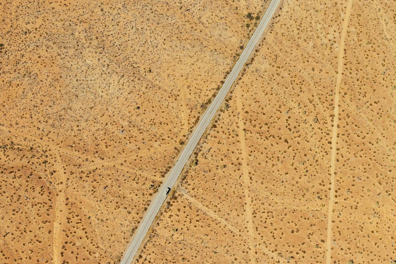 Desert ground seen from above, crossed by faint tracks